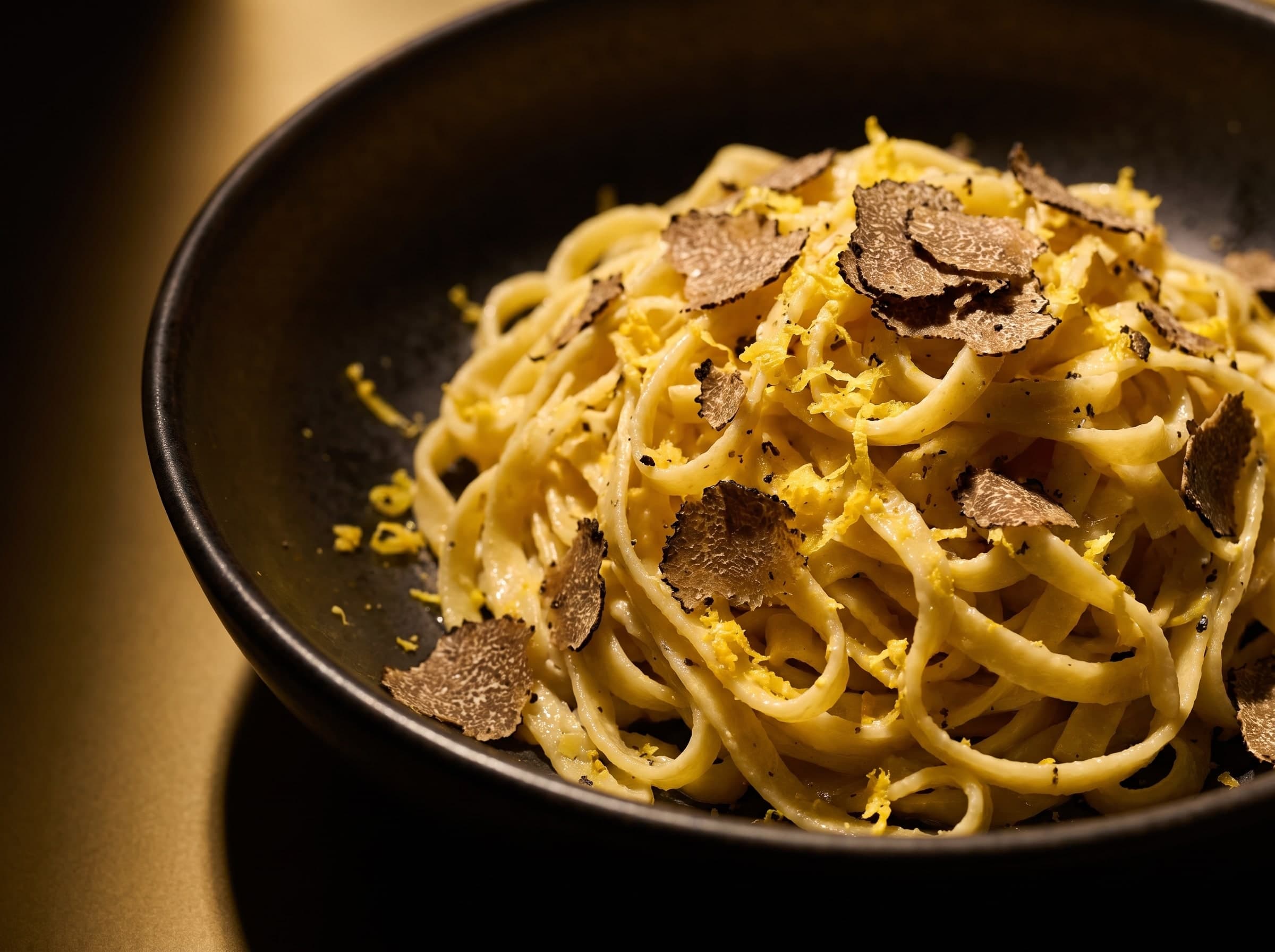 Tagliolini au zeste de citron et à la truffe noire râpée dans un bol sombre